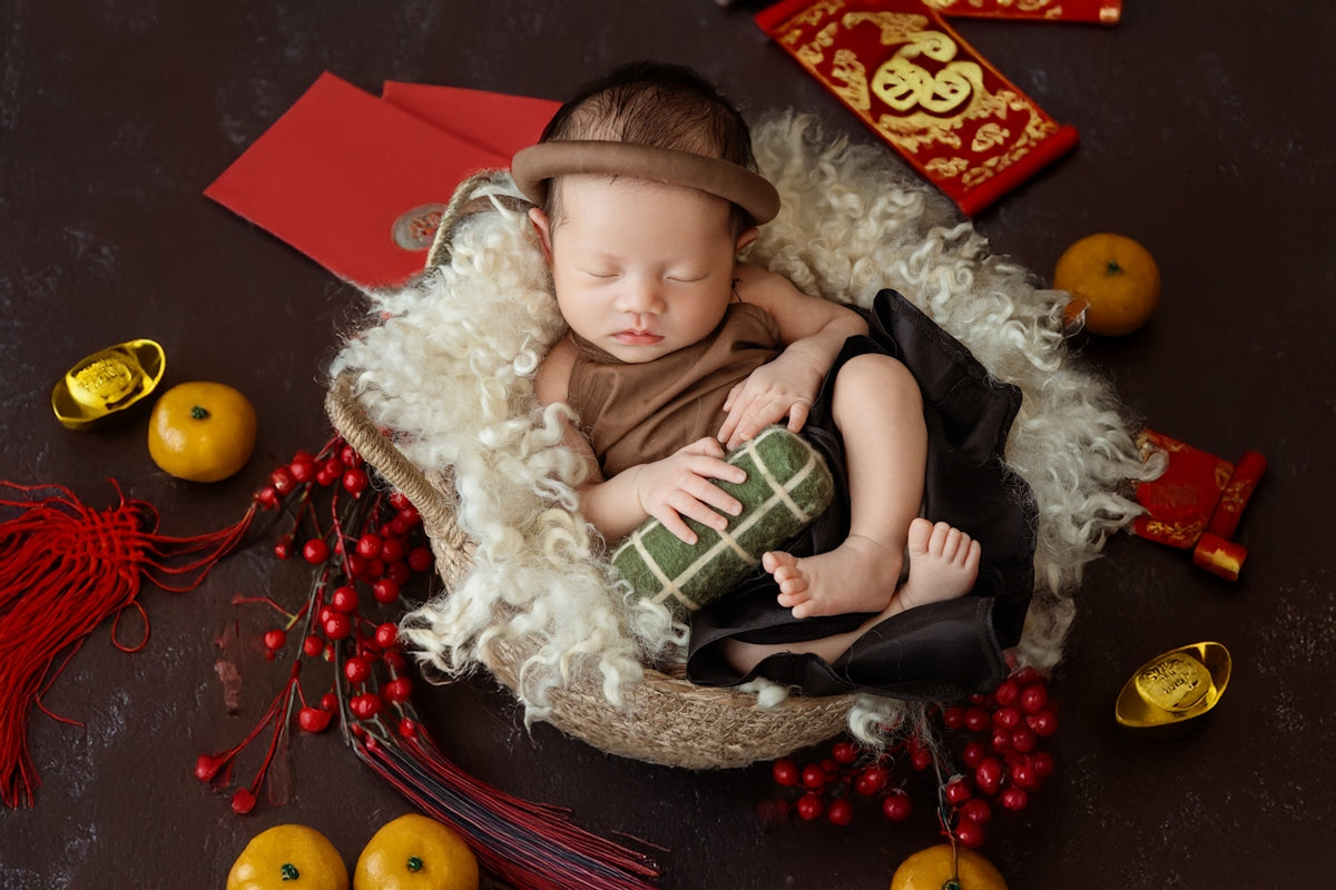 A baby is sleeping in a bowl with decorations around it