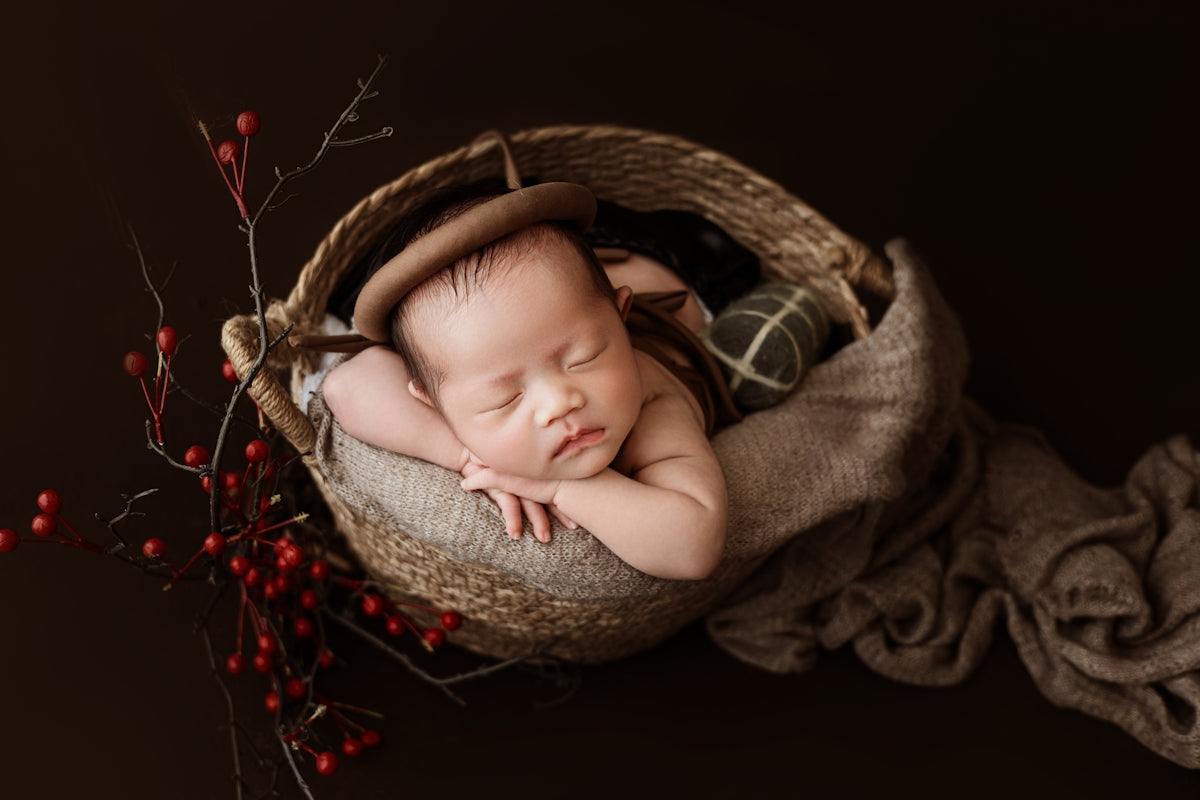 A newborn baby is sleeping in a basket