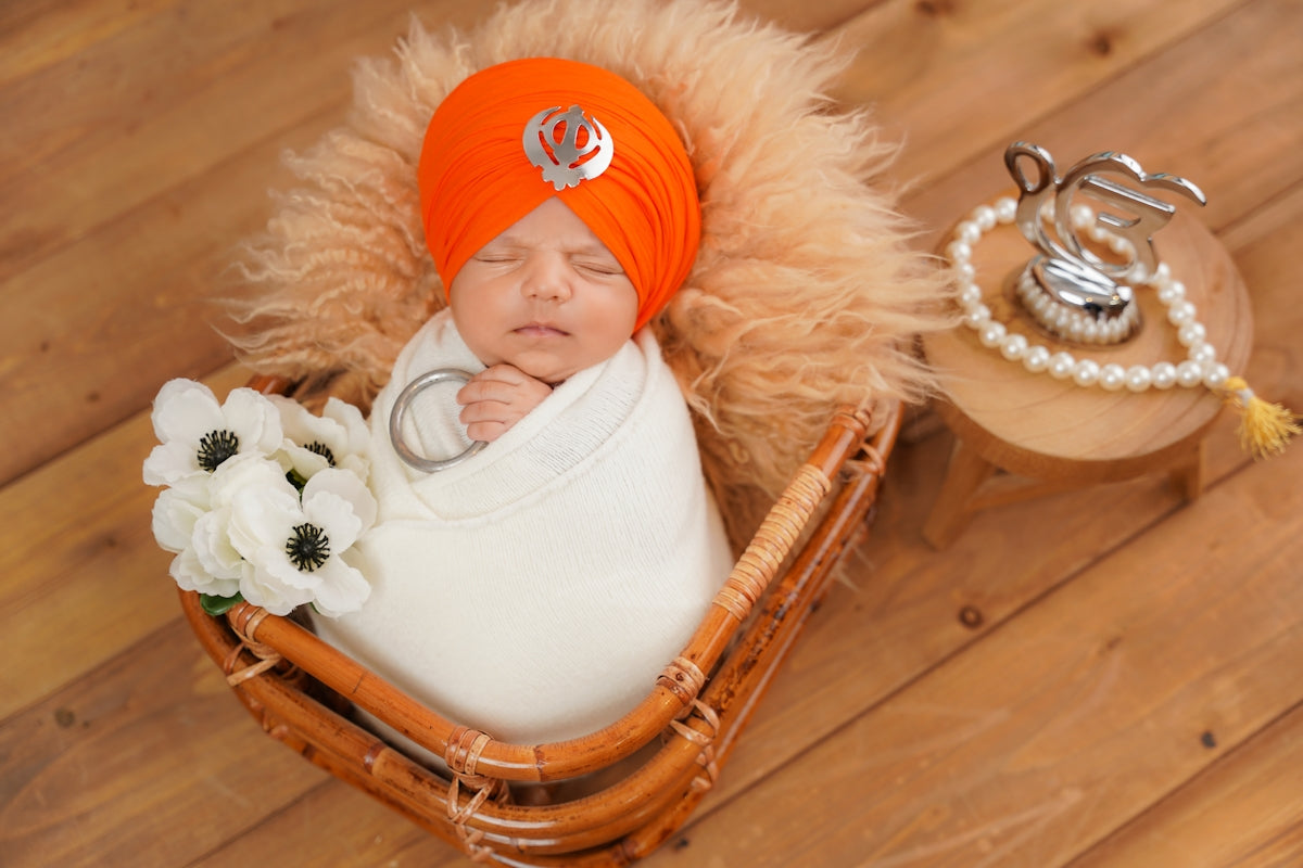 Newborn baby wrapped in a turban and blanket.